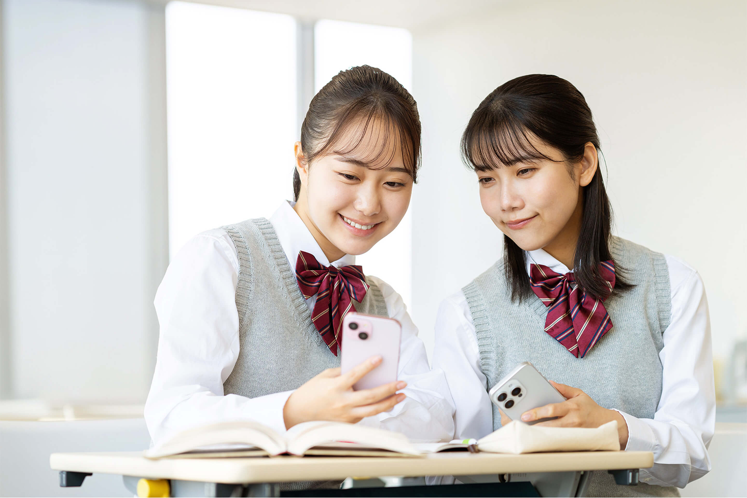 図書館でスマートフォンを見ながら学習する学生の様子